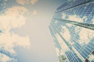 a tall modern skyscraper taken from the ground to represent how cybersecurity can help business growth