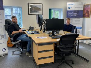 Zack Thompson, IT Technician and Daniel Hildred, Director, sitting at their desks in the Comprendo office.