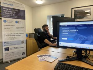Our technician Zack Thompson sitting at his desk in the Comprendo offices, on the telephone to an IT administrator