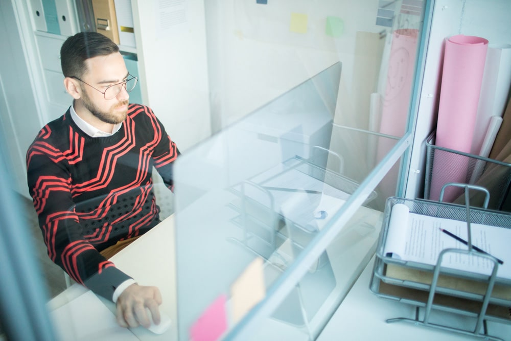 Man sitting by computer doing managed service provider tasks