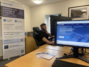 One of Comprendo's IT support team members sat at a desk on the telephone