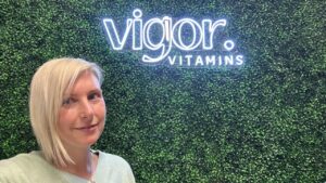 Rachel Beck standing in front of her Vigor Vitamins signage